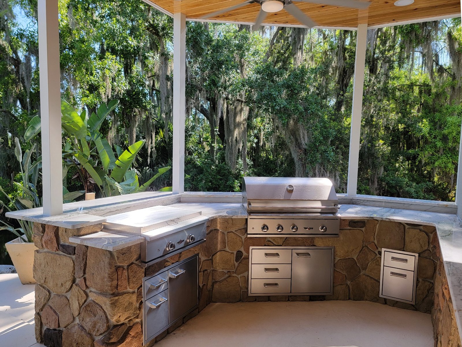 Outdoor grill and counters surrounded by tropical planting