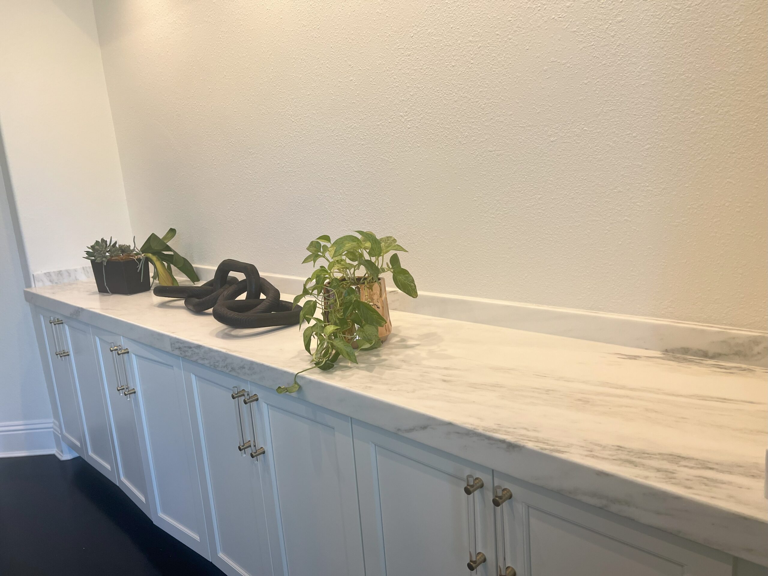 Long stone countertop above blue-gray cabinetry from the United Stone gallery