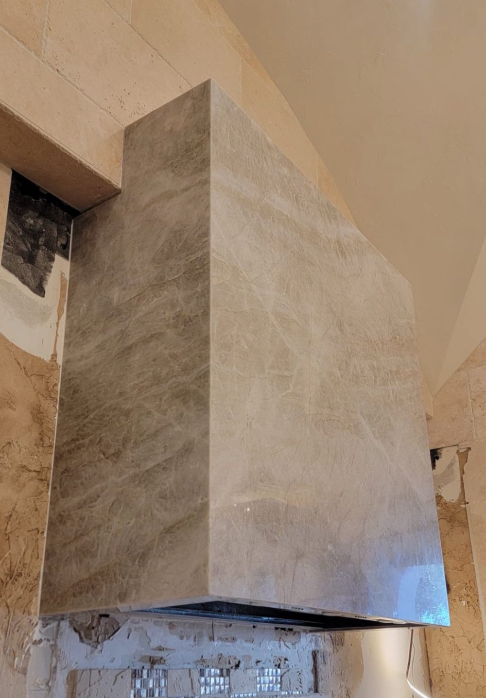Stone-clad range hood with angled edges